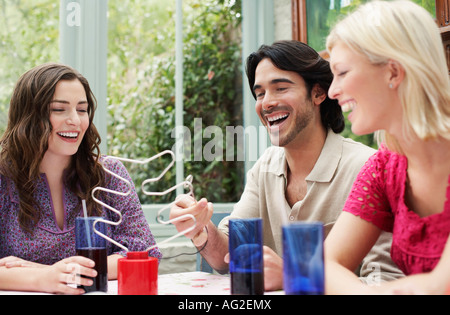 Groupe de jeunes gens assis à la table de la véranda Banque D'Images