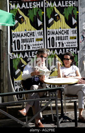 France Marseille Marché en marche des Capucins Noailles Salon est fortement en arabe une affiche s'asseoir un couple de touristes parisiens Banque D'Images