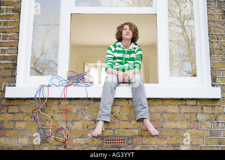 Teenage boy sam on windowsill Banque D'Images