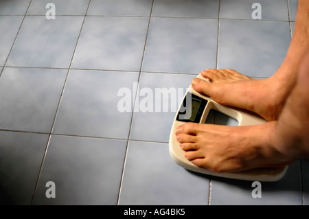 Homme debout sur une échelle de poids salle de bains Banque D'Images