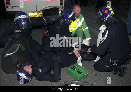 Collègues policiers et un infirmier ont tendance à policier blessés dans des émeutes à l'anti-Parti national britannique mars,Welling, Londres 1994 Banque D'Images