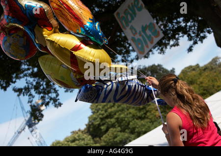 Ballon rempli d'hélium femelle vendeur à l'extérieur dans un parc public Banque D'Images