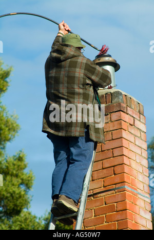Un ramoneur à la cheminée de nettoyage d'un travail Banque D'Images