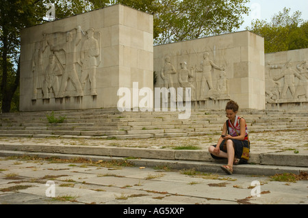 Girl écrit un sms au panthéon du mouvement de la classe ouvrière en monument Cimetière Kerepesi au centre de Budapest, Hongrie UE Banque D'Images