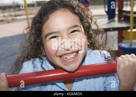 Libre de dix ans, fille de faire une remontée au cours de gym and smiling Banque D'Images