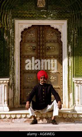 Inde Rajasthan Jaipur City Palace gardien en uniforme assis dans la porte d'ornement Banque D'Images