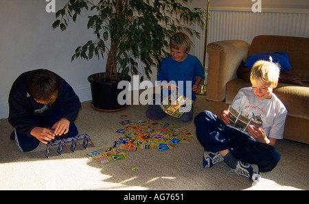 Trois garçons jouant avec des cartes Pokemon Banque D'Images