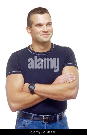 Portrait d'une sportive musculaire homme avec ses bras croisés et vêtus de vêtements casual shot sur un fond blanc. Banque D'Images