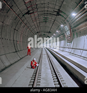 Les ingénieurs de contrôle examiner une section remplie de tunnel ferroviaire du tunnel sous les voies et des passerelles permanentes avec installés. Banque D'Images