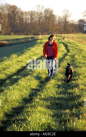 Woman in red jacket walking dog le long de la digue de la rivière Snohomish Washington Snohomish Banque D'Images