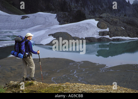 Randonneur avec vue sur lac alpin et meadows North Cascades Cascades Washington Banque D'Images