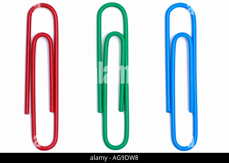Trombones de bureau contre un fond blanc trois objets disposés comme rouge, vert et bleu Banque D'Images