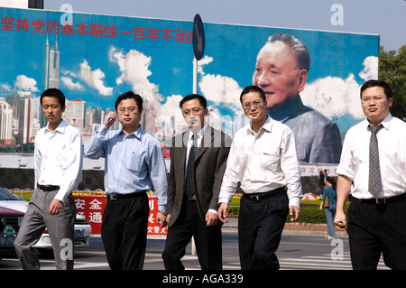 Les employés de bureau à pied en face d'une peinture murale de Deng Xiao Ping qui commémore la fondation de Chines première Zone économique spéciale 2 Banque D'Images