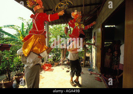 Bord danse avec les garçons sur leurs épaules à l'extérieur de la chambre des parents de la Poy a chanté longtemps Mae Hong Son, Thaïlande Banque D'Images