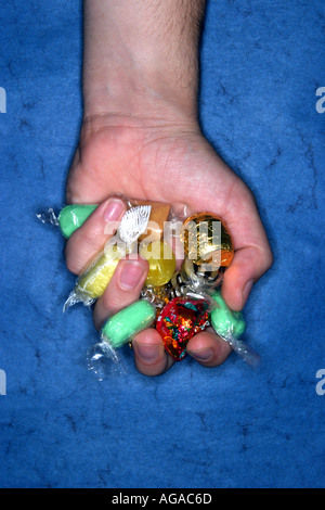 L'homme s hand holding sweets Banque D'Images