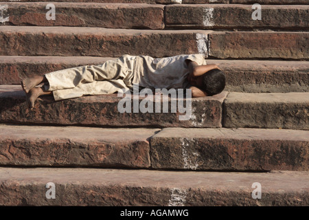 Un jeune homme endormi sur les marches de la mosquée Jama Masjid à Delhi Inde s plus grande mosquée Banque D'Images