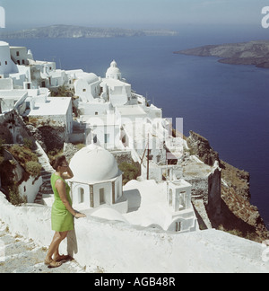 Les touristes à la recherche de la vue depuis les étapes et les ruelles blanchies à la chaux de l'île de Santorini, Cyclades, Grèce, Mer Egée Banque D'Images