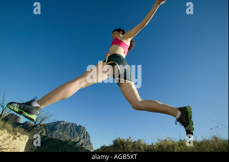 Coureuse sautant avec fond de montagne Banque D'Images