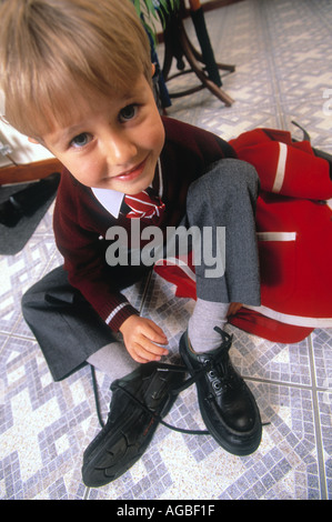 Close up of boy en uniforme d'attacher les lacets de chaussures Banque D'Images