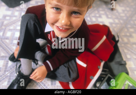 Close up of boy en uniforme d'attacher les lacets de chaussures Banque D'Images