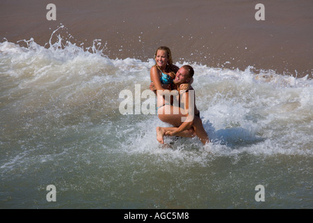 Jeune couple jouant dans l'océan à Manhattan Beach, Californie, USA Banque D'Images