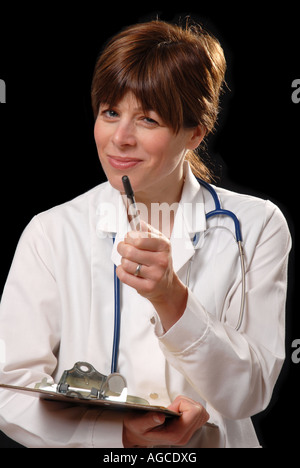 Attractive young woman in white coat with stethoscope & presse-papiers à poser des questions Banque D'Images