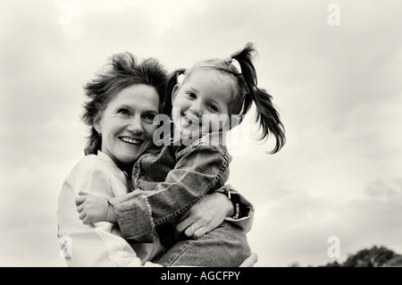 Portrait noir et blanc d'une petite fille avec sa mère à l'extérieur Banque D'Images