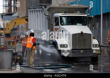 Les travailleurs de la construction de la tour de la liberté à laver la poussière et saleté de camions à leur sortie du site de Ground Zero. Banque D'Images