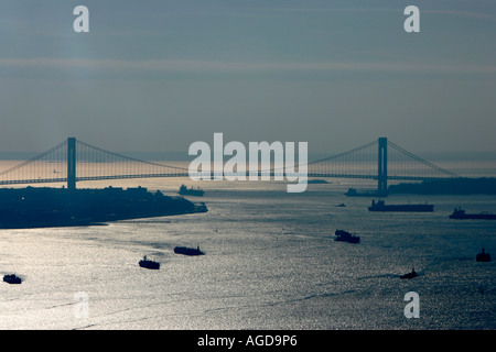 des navires-avions naviguent dans le port de la baie de new york sous verrazano pont de narrows en lumière du soleil dorée aux états-unis Banque D'Images