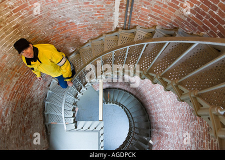 L'homme descend escalier circulaire à l'intérieur de Cape Blanco light house New York Banque D'Images