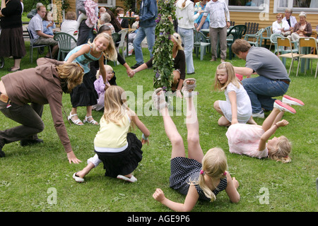 Les familles s'amuser au milieu de célébration en Suède. Maypole et danser autour du pôle en plein été Banque D'Images