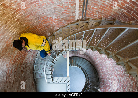 L'homme descend escalier circulaire à l'intérieur de Cape Blanco light house New York Banque D'Images