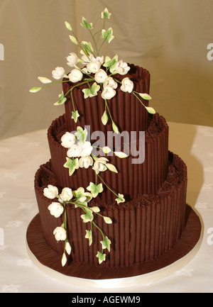 Chocolat étagée gâteau de mariage décoré avec gerbe de fleurs comestibles blanc debout sur le tableau