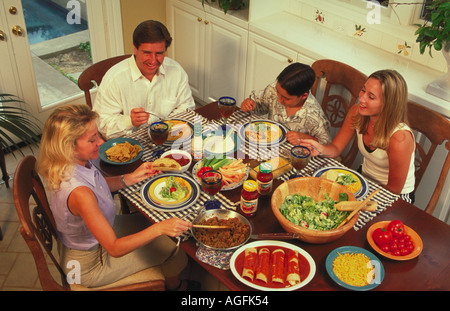 Vue aérienne d'une mère père fils et fille de s'asseoir pour un dîner de salades tacos et enchiladas Banque D'Images