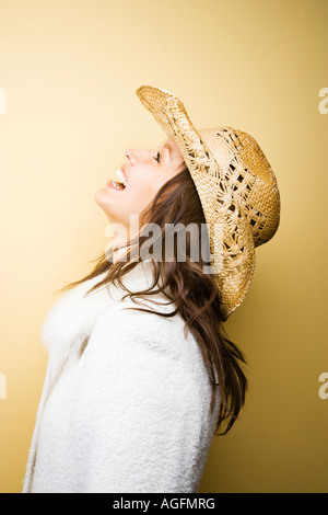 Profil des jeunes adultes en Caucasian woman wearing cowboy hat se penchant en arrière en riant Banque D'Images