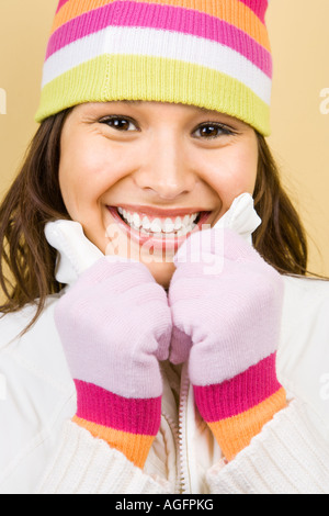 Young adult Caucasian woman wearing winter hat and gloves and smiling at viewer Banque D'Images