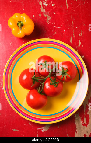 Cinq tomates sur plaque avec poivron jaune Banque D'Images