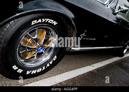 La roue avant gauche d'un classique de 1968 Ford Mustang Boss. Roues en alliage et lustrée mis en évidence par le disque flash direct. Banque D'Images