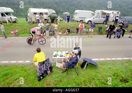 Spectateurs regarder le Tour de France 2004 la montre sur le côté de la route tout en ayant un pique-nique avec vin Banque D'Images