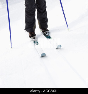 Close up de skieurs jambes chaussures bâtons et skis debout sur la pente Banque D'Images