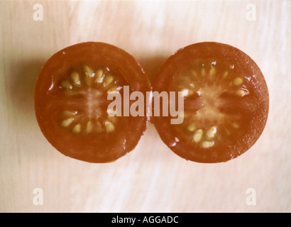 Les deux moitiés d'une tomate cerise Banque D'Images