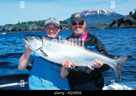 Les skippers de bateaux de pêche au saumon de la location et un client avec un Saumon quinnat pris à bord du Grand Bleu Sitka Alaska Charters Banque D'Images