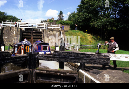 Péniches passant par verrou à bingley hausse cinq serrures avec lockeeper mécanisme de fonctionnement vanne yorkshire uk Banque D'Images