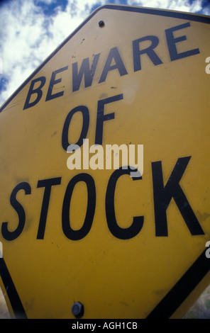 Gros plan du Australian méfiez-vous de stock attention panneau routier. Caractères noirs avec lettrage graphique jaune signe métallique et fond de ciel bleu. Banque D'Images