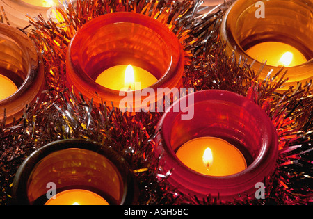 Plusieurs feux de thé brûlant dans le verre coloré à Noël avec les guirlandes entre eux Banque D'Images