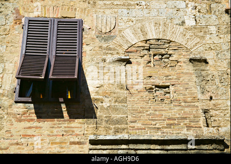 Ouverture partielle, à côté de la fenêtre aux volets murée, archway San Gimignono, Toscane, Italie Banque D'Images