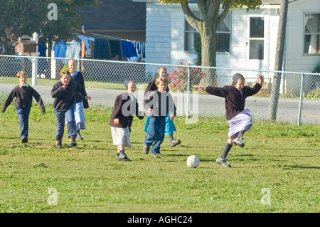 Les enfants jouent au soccer dans la cour d'école à la récréation de la vie Amish à Millersburg et Sugar Creek Holms Ohio Comté Banque D'Images