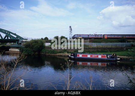 Barge Canal en tirant les amarres et train électrique qui passe, de la rivière Trent, Newark Nether Lock, Nottinghamshire, Royaume-Uni. Banque D'Images