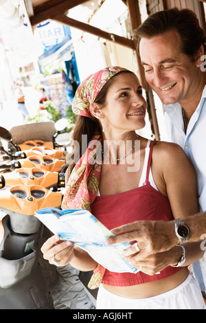 Close-up of a young couple holding un catalogue and smiling Banque D'Images