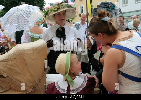 Mère d'aujourd'hui d'admirer bébé il y a d'années dans la pram et suranné, mesdames en costumes autour de 1900 Allemagne Bavière Bad Tolz Banque D'Images